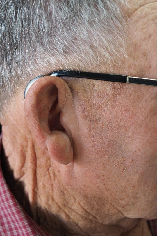 old man with hearing aid